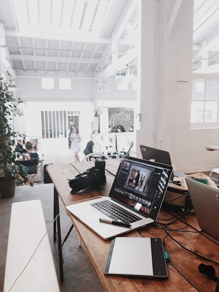 The Art of Drawing Readers In: Your attractive post title goes here A bright, modern workspace featuring laptops, a camera, and a drawing tablet in an indoor office.